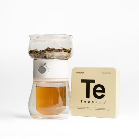 Brewed Teanium TOVLA Georgian White tea in glass infuser next to tin pocket box